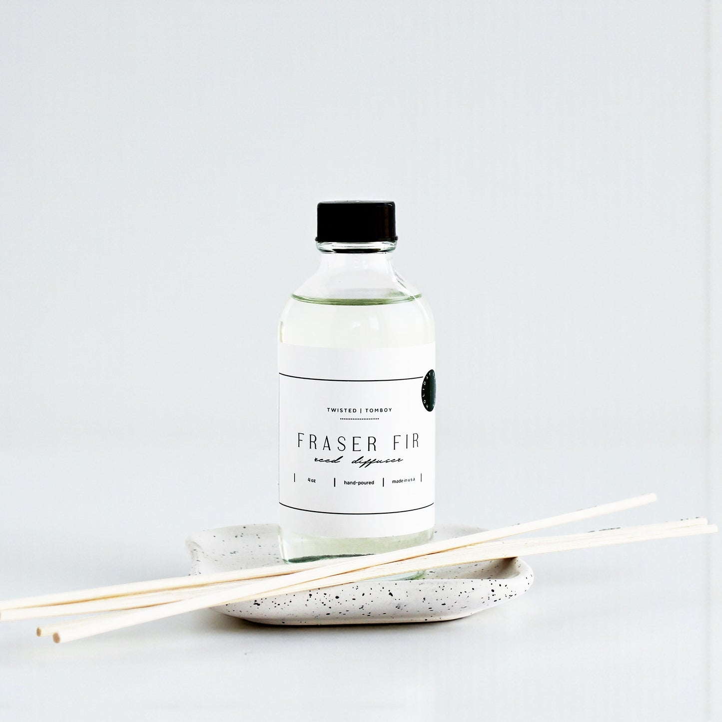 Bottle of Fraser Fir reed diffuser with sticks on a white background