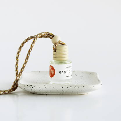 Mango+Coconut with a gold string on a speckled ceramic dish against a white background