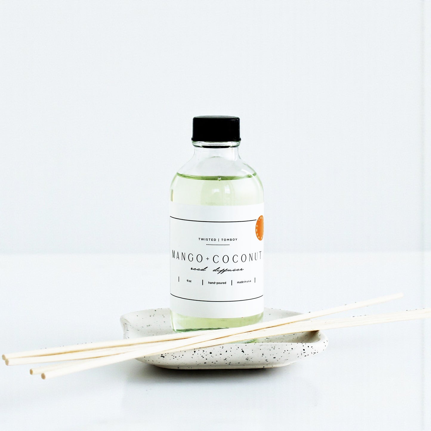Bottle of Mango-Coconut Reed Diffuser with sticks on a white background