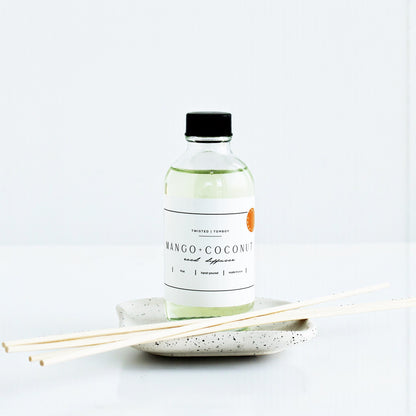 Bottle of Mango-Coconut Reed Diffuser with sticks on a white background