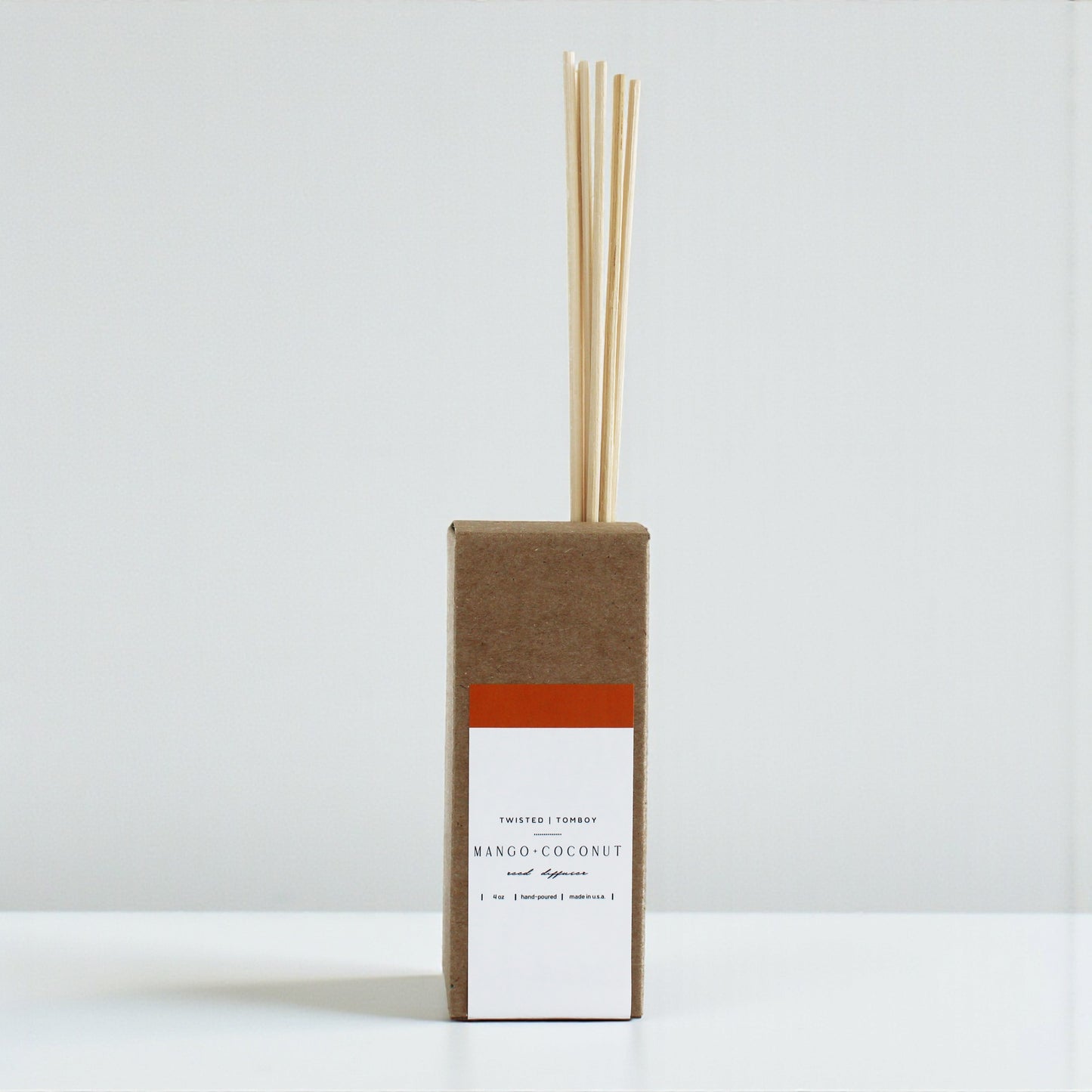 Mango+Coconut reed diffuser with cardboard packaging on a white background