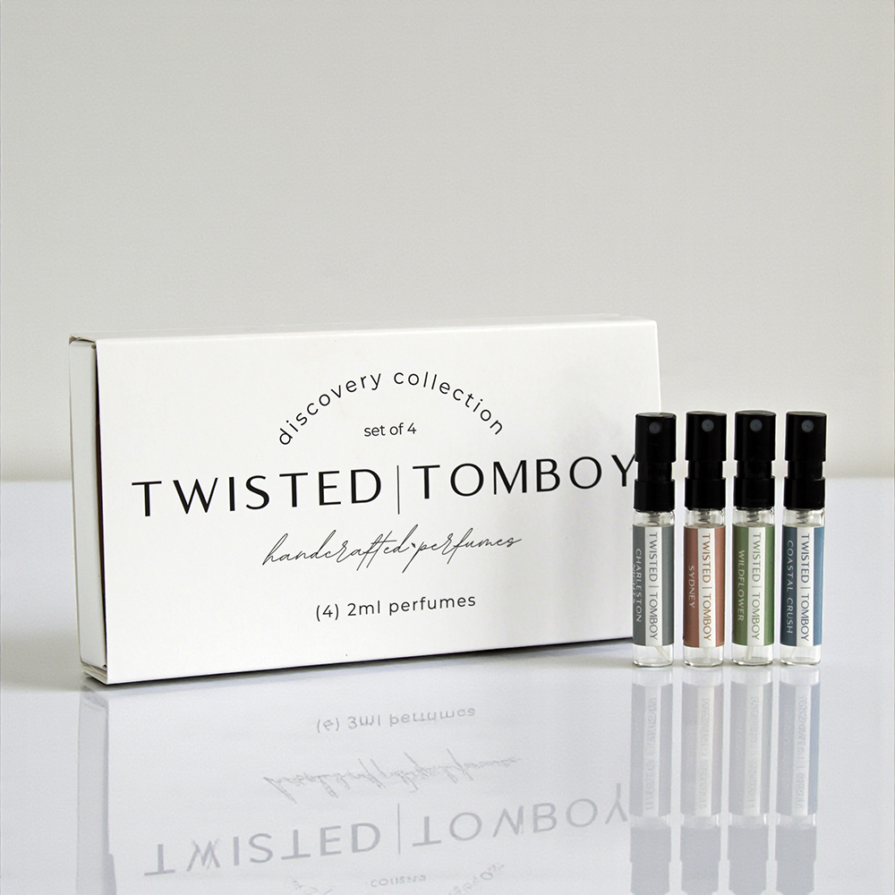Twisted Tomboy perfume set with packaging on a reflective surface