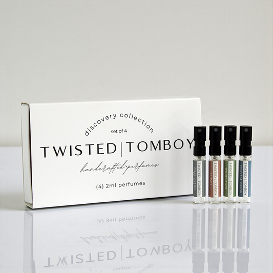 Twisted Tomboy perfume set with packaging on a reflective surface