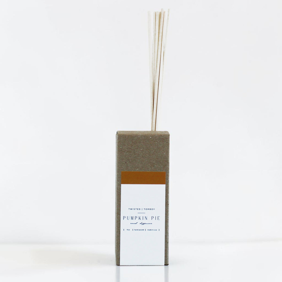 Reed diffuser with a rectangular box labeled 'Pumpkin Pie' on a white background