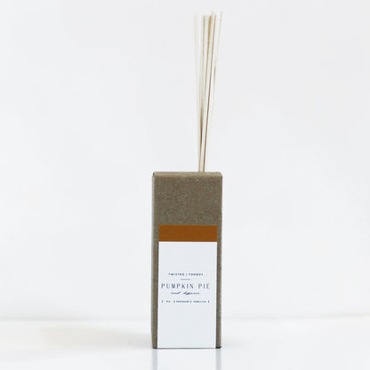 Reed diffuser with a rectangular box labeled 'Pumpkin Pie' on a white background