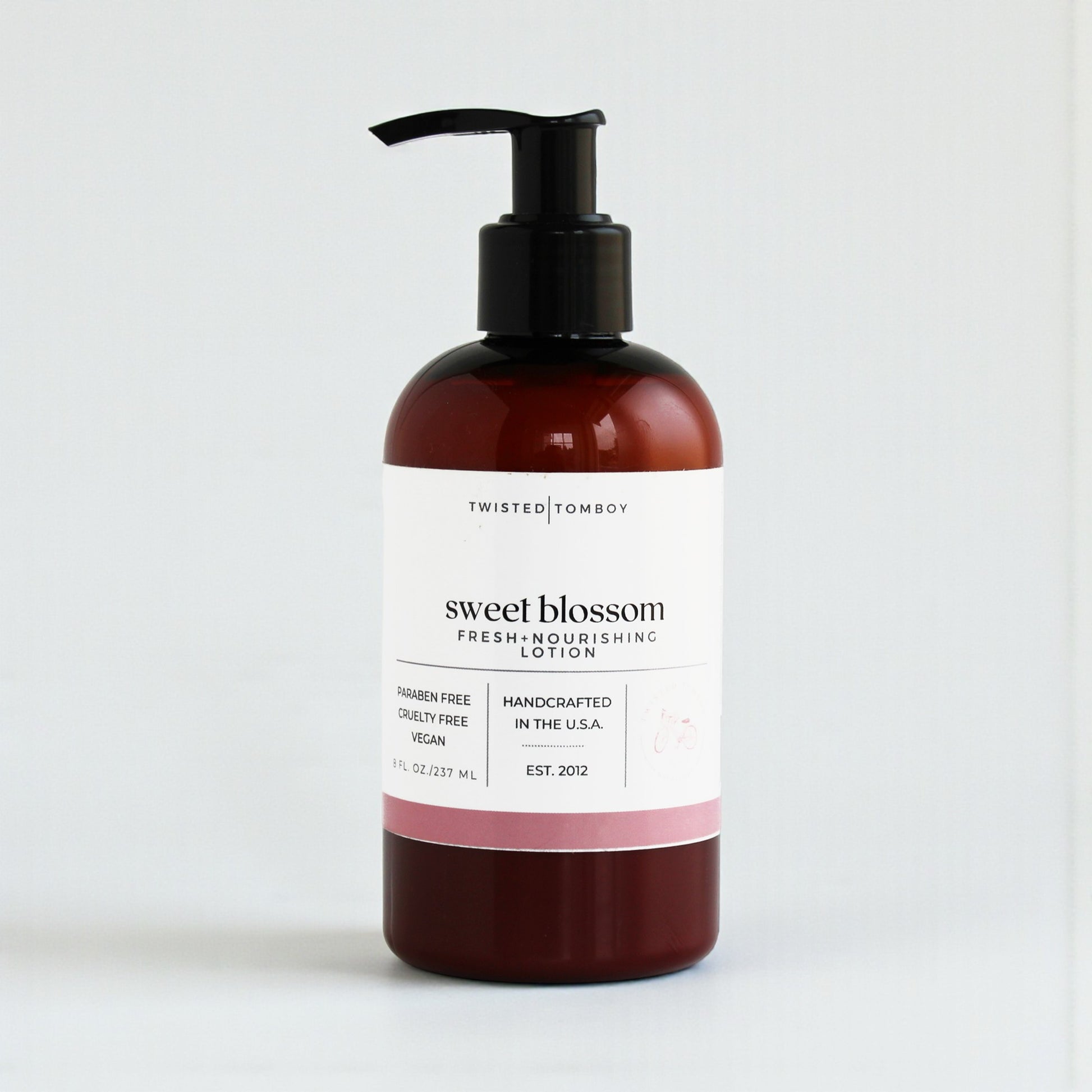 Lotion bottle labeled 'sweet blossom' by Twisted Tomboy on a white background