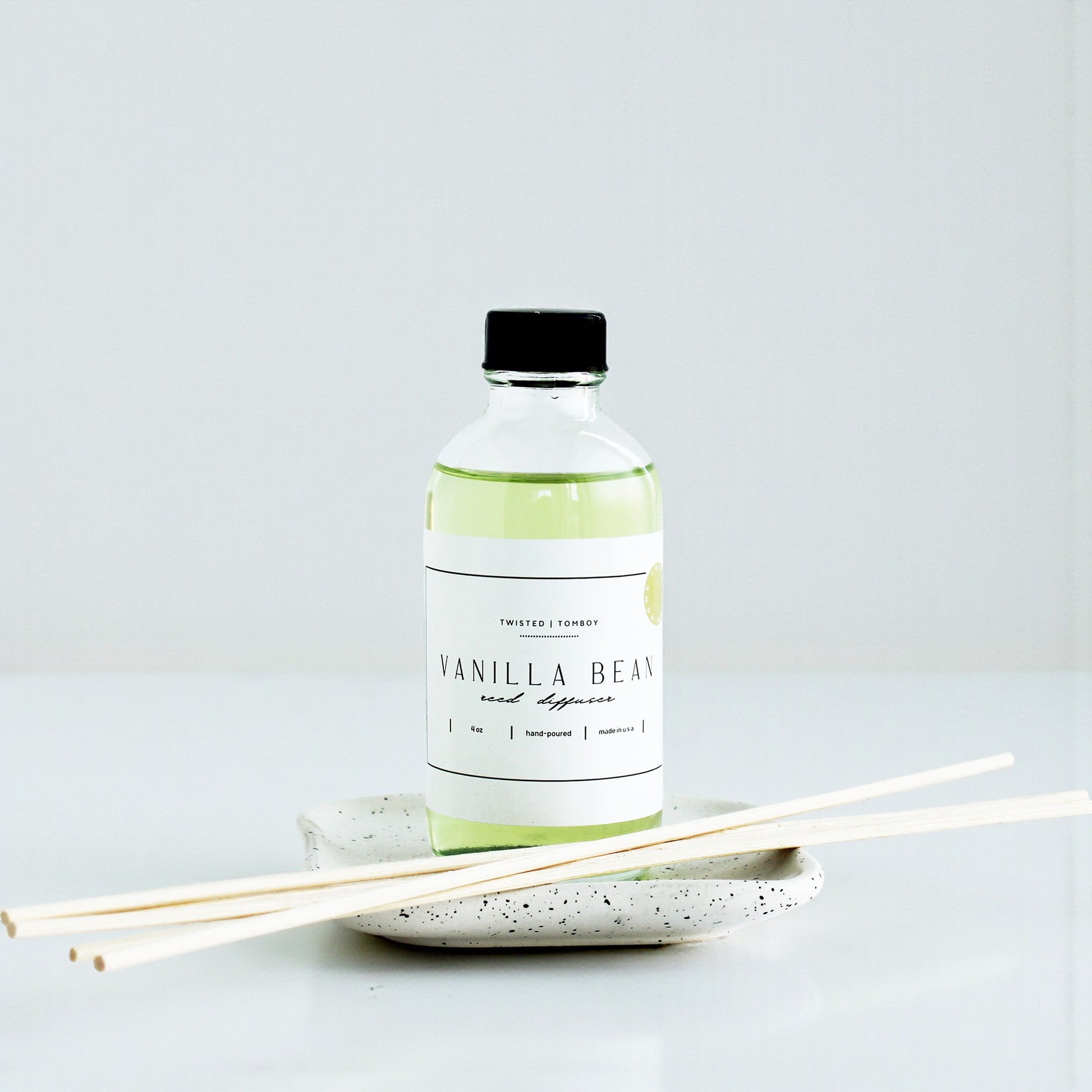 Vanilla bean diffuser bottle with sticks on a white background