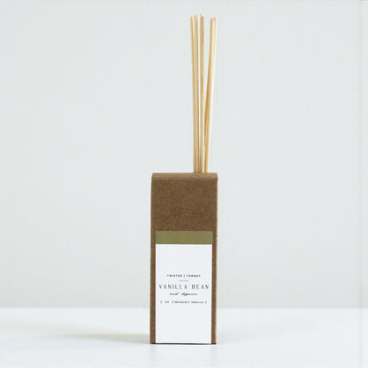 Vanilla bean diffuser with reeds in a cardboard box on a white background