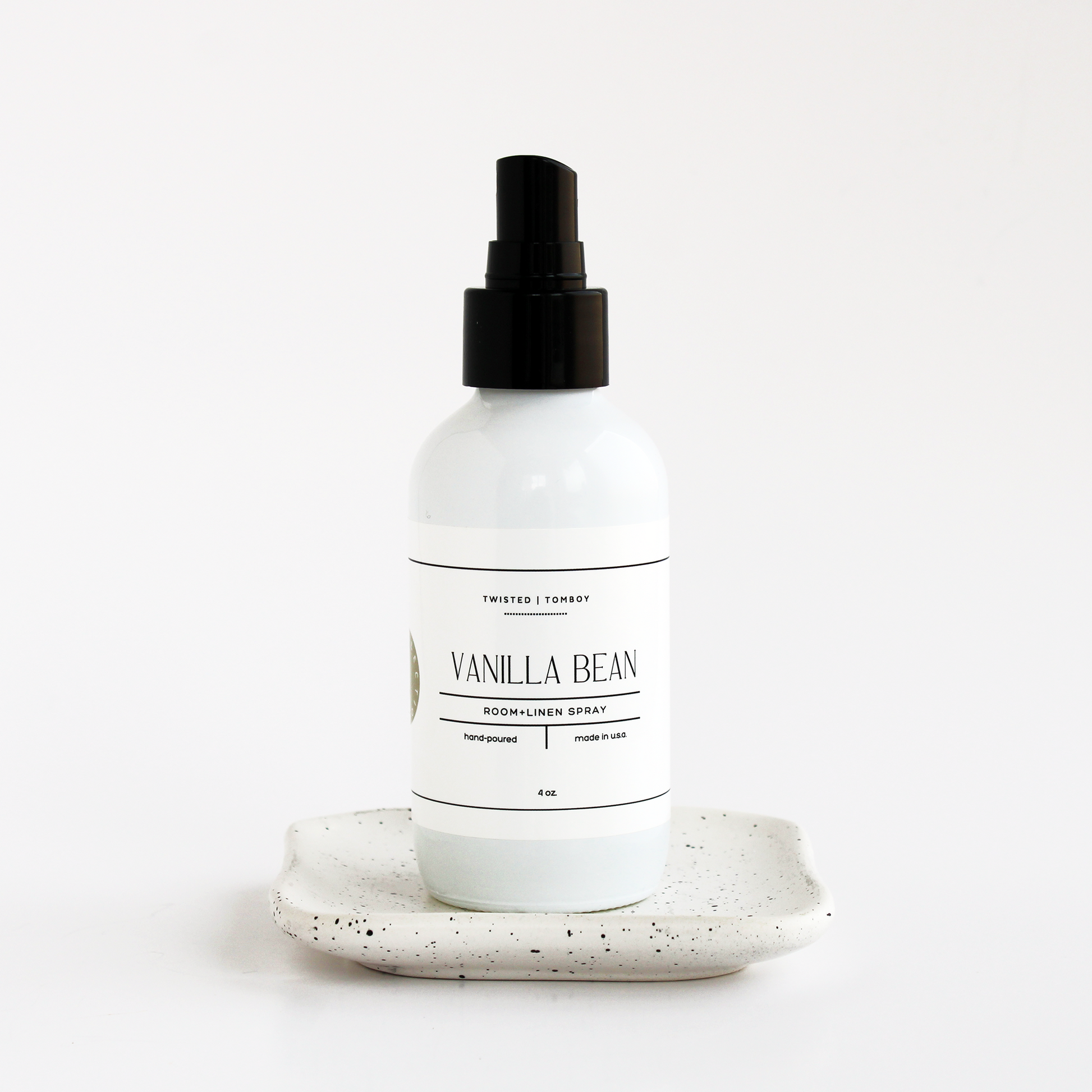 Vanilla Bean Spray in white bottle sitting on small dish