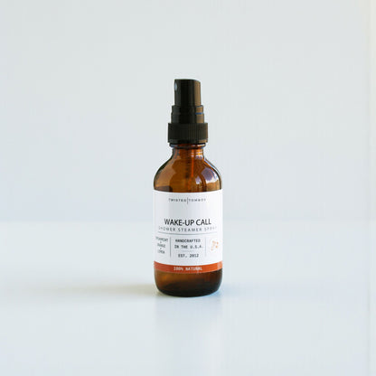 Brown glass bottle with black spray nozzle on a white background, Wake-Up Call scent