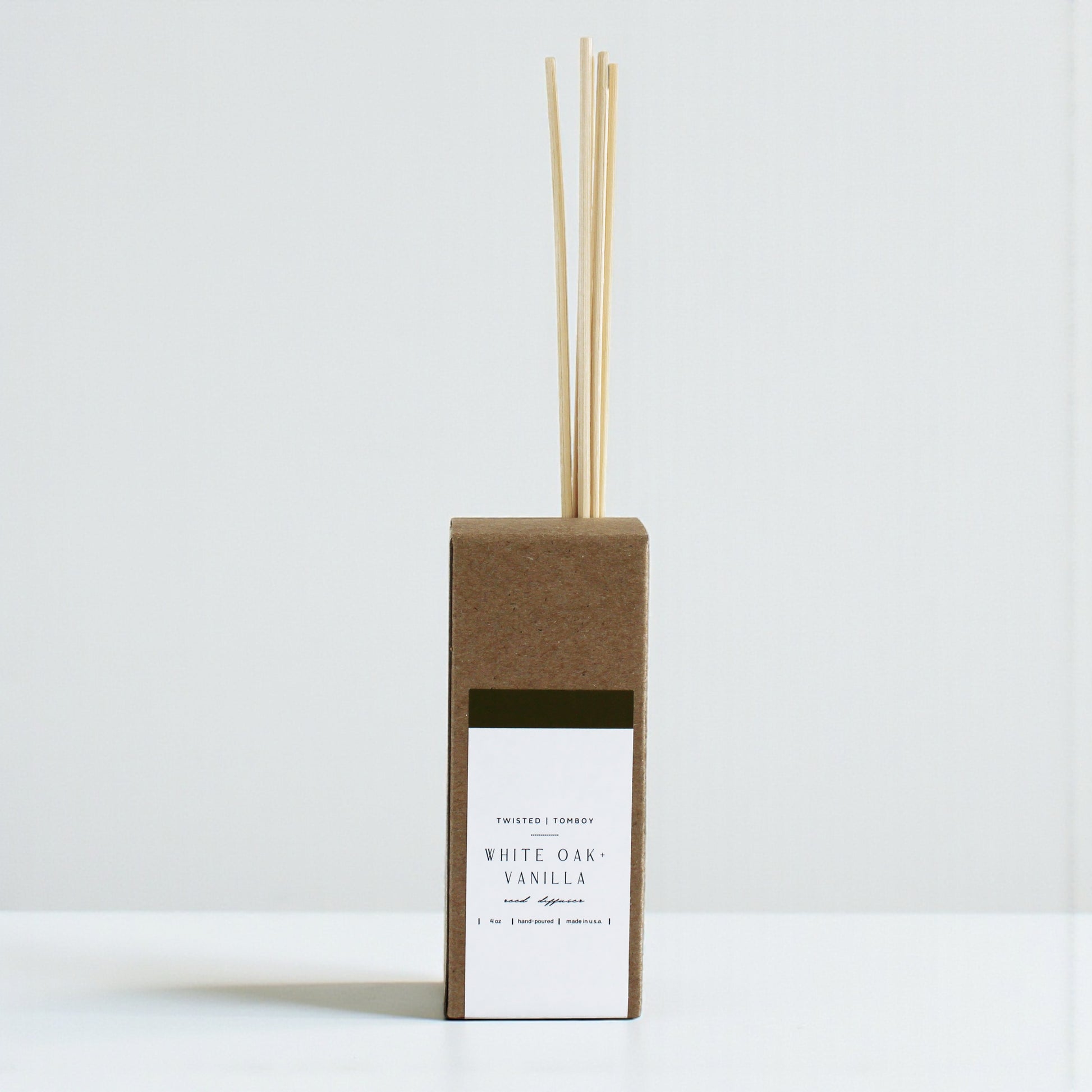 White Oak+Vanilla reed diffuser with wooden sticks in a cardboard box on a white background