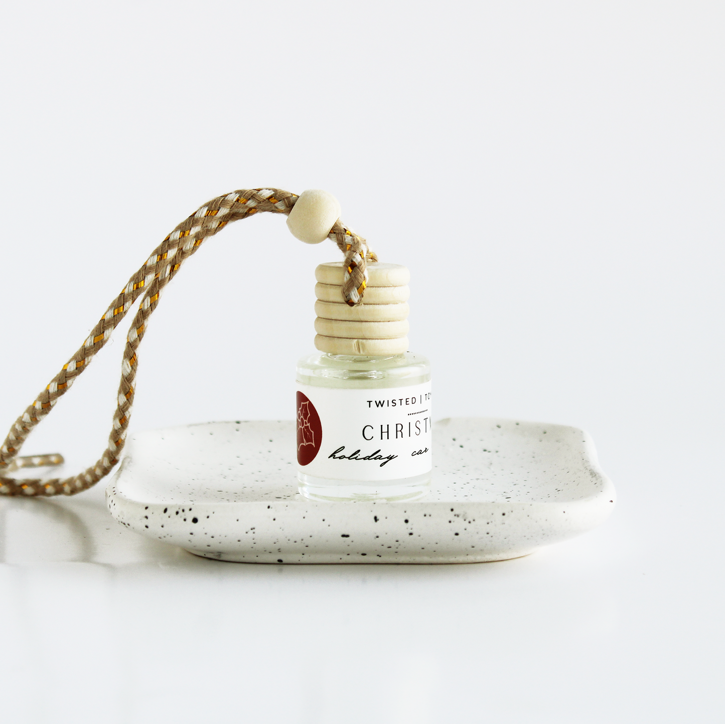 Christmas car diffuser with string sitting on small dish
