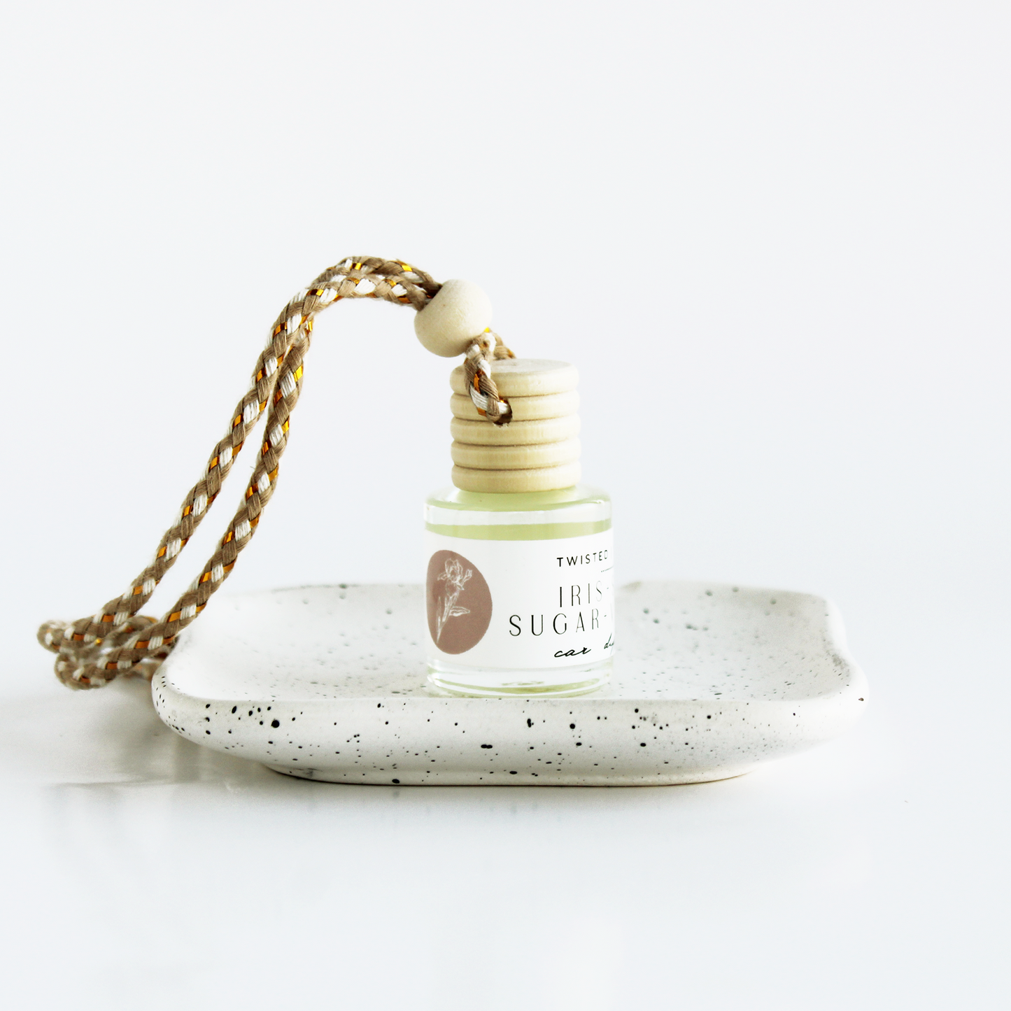 Small bottle labeled Iris+Vanilla+Spun Sugar sitting on dish