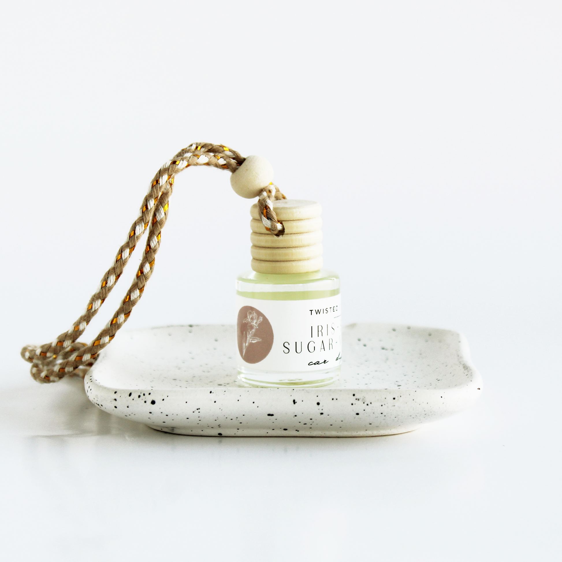 Small bottle labeled Iris+Vanilla+Spun Sugar sitting on dish