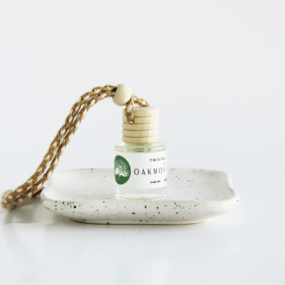 Oakmoss+Amber Car Diffuser Bottle on cream dish