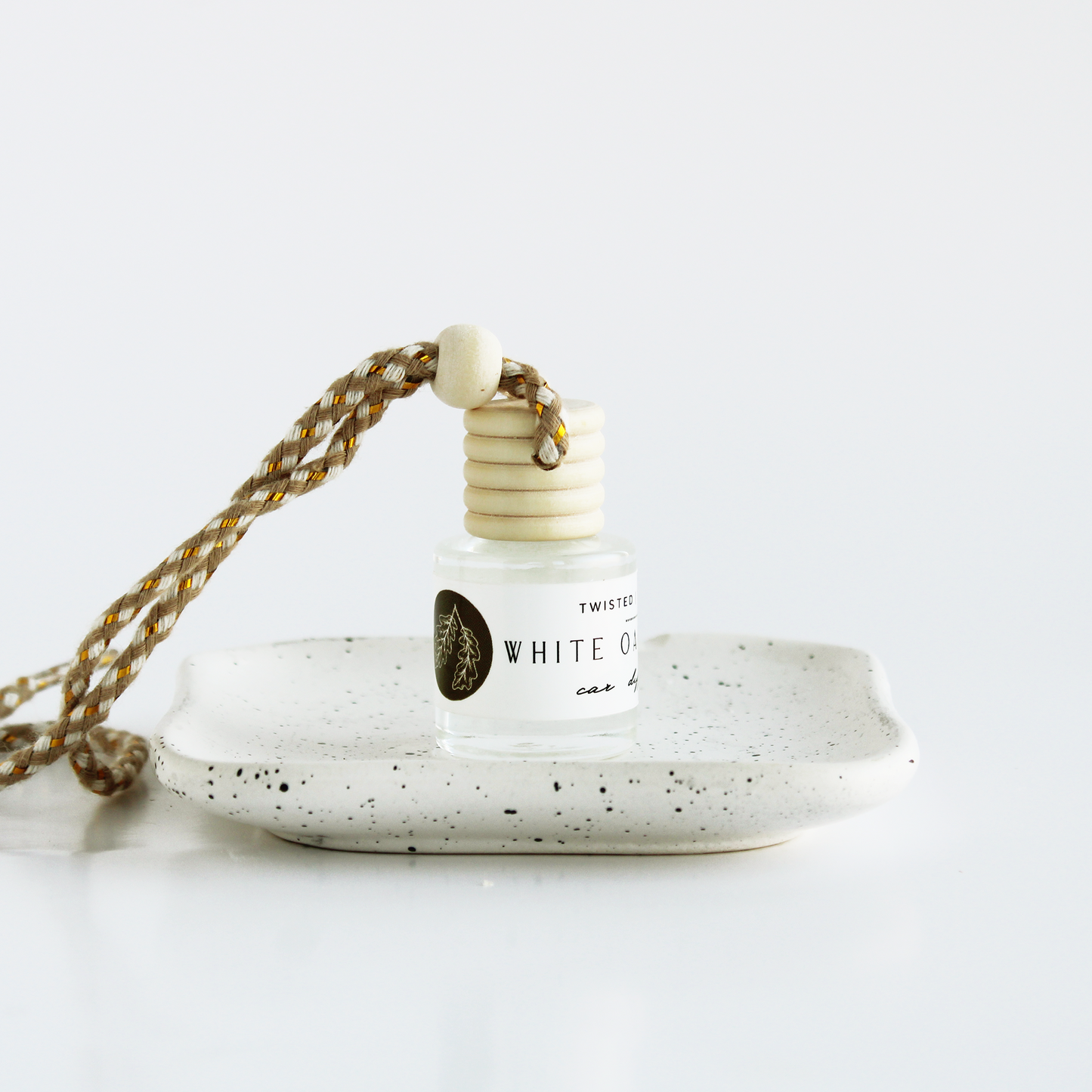 White Oak+Vanilla bottle with a speckled ceramic holder on a white background
