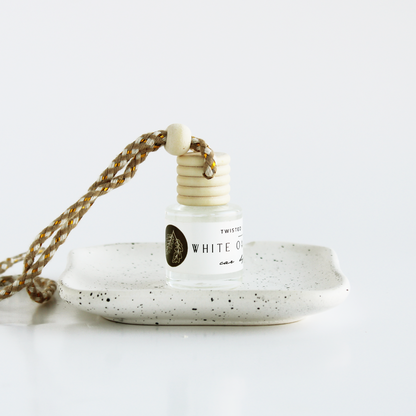 White Oak+Vanilla bottle with a speckled ceramic holder on a white background