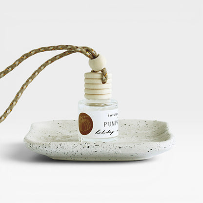 Pumpkin pie car diffuser on a speckled ceramic plate with a white background