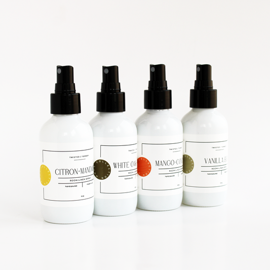 Four white spray bottles with black nozzles on a white background