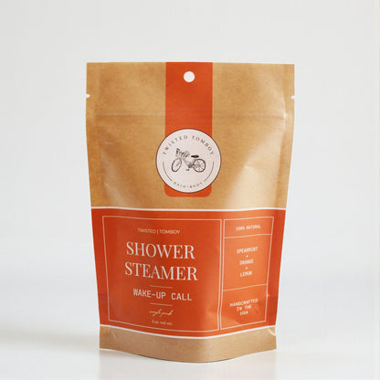 Shower Steamer SINGLES in a kraft paper pouch with orange accents, featuring a spearmint, orange, and lemon scent.